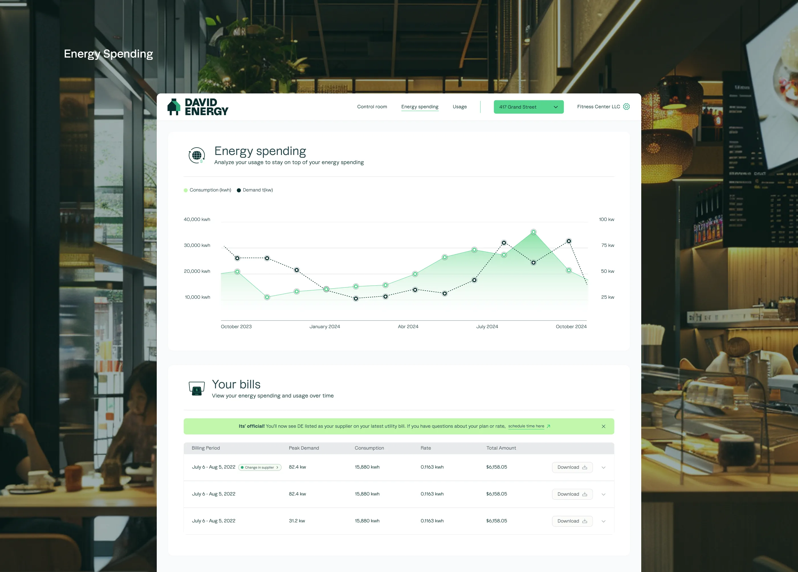 Energy Spending dashboard — MacBook in restaurant setting showing consumption and demand chart with billing table