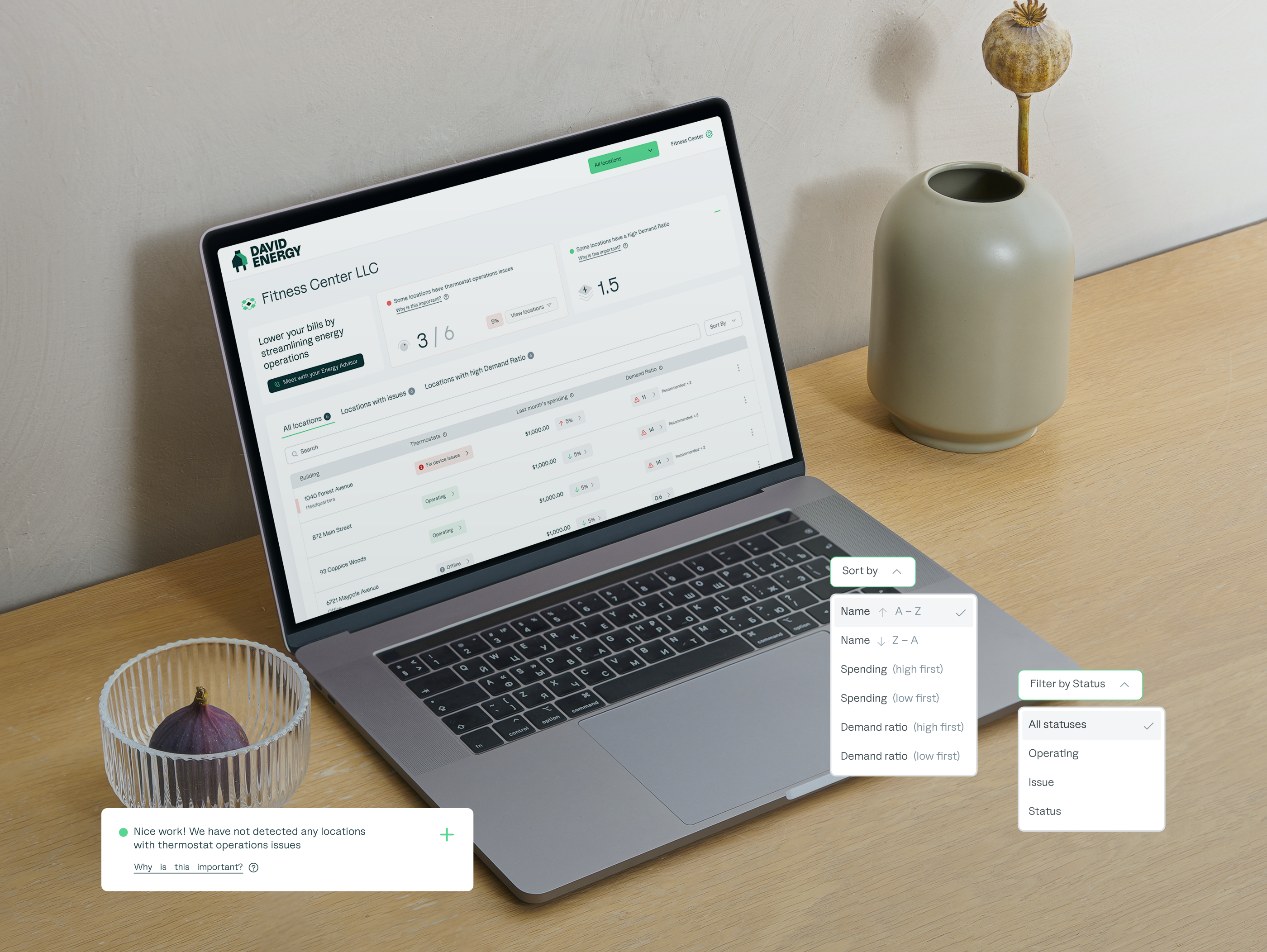 All Locations dashboard — MacBook on desk showing facility portfolio overview with sort and filter controls