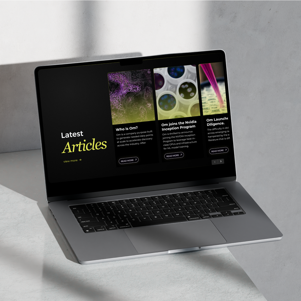 Om Therapeutics Latest Articles page on MacBook — dark editorial layout with molecular photography