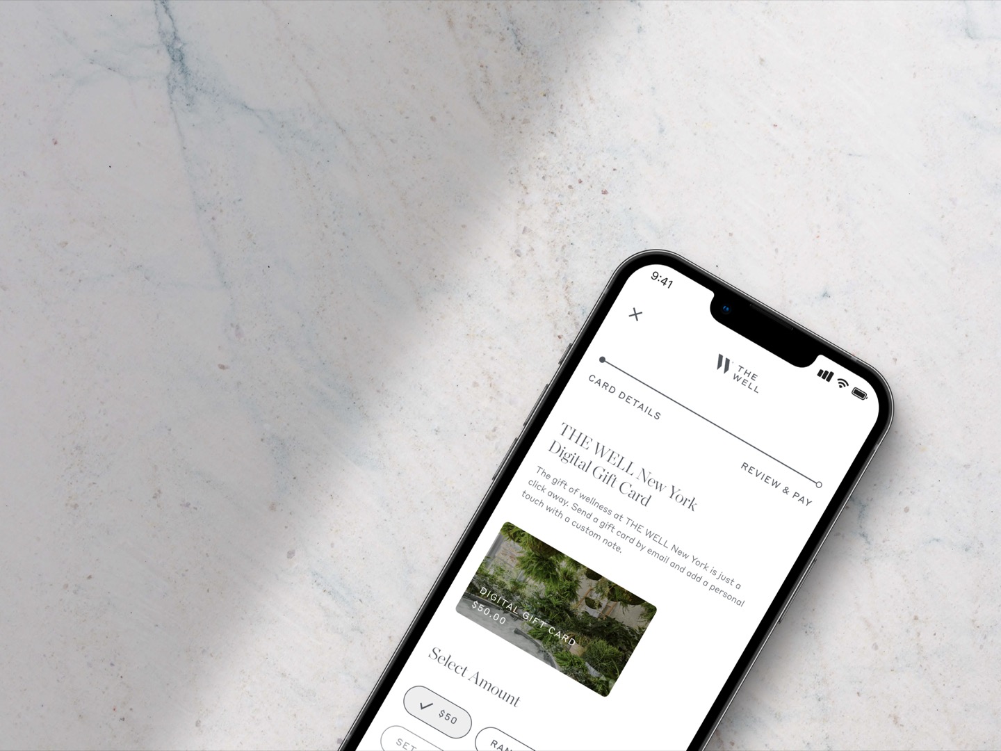 The Well gift card experience shown on laptop and phone with customizable card designs and purchase flow